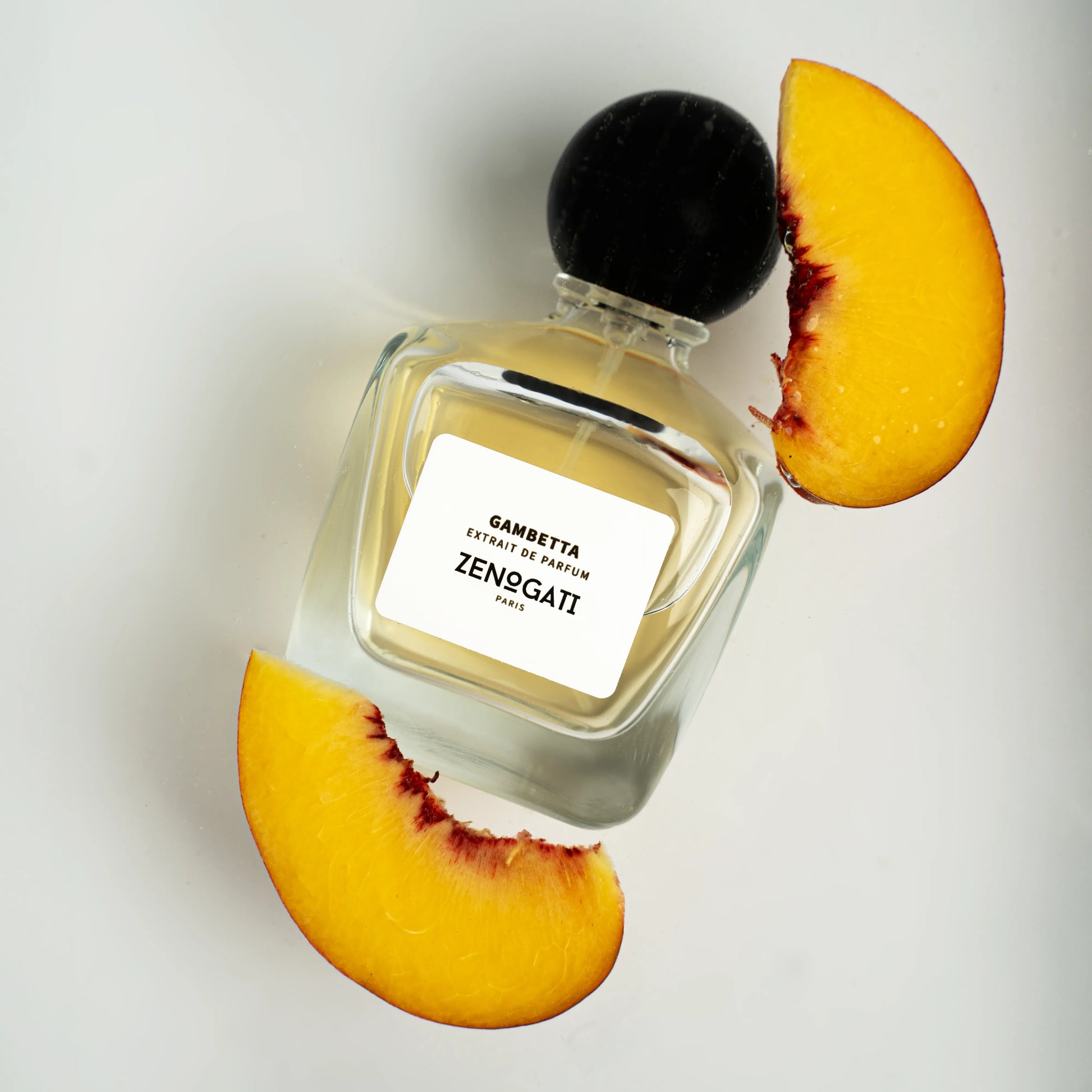 Flacon Gambetta de Zenogati — parfum unisexe fruité-floral chaleureux mêlant poire, pêche et prune en tête, cœur de rose rouge, jasmin et cannelle, posé sur un fond gourmand de caramel, muscs et cèdre de Virginie pour un sillage élégant et sensuel