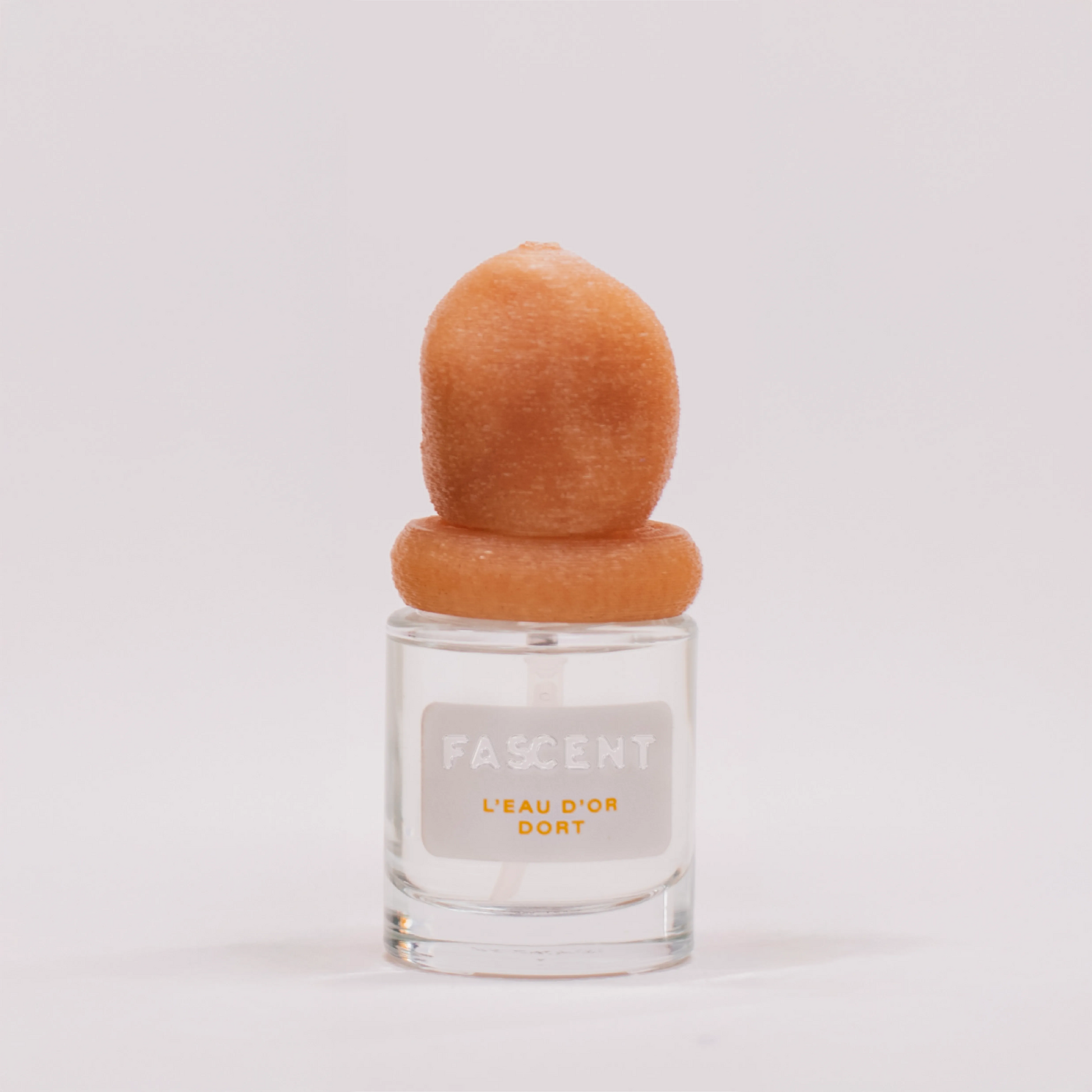Flacon L’Eau d’Or Dort de Fascent — parfum unisexe lumineux mêlant notes d’agrumes (bergamote, cédrat, citron), fleur d’oranger, petit grain et musc blanc, évoquant la fraîcheur d’un matin doré, pure et sereine.