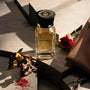 Omanluxury - Paramour parfum de niche unisexe 100ml avec des roses du oud du cuir sur une table