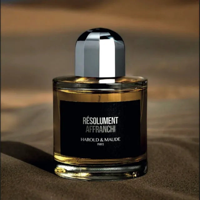 Flacon Résolument Affranchi de Harold & Maude — parfum unisexe floral-épicé boisé qui s’ouvre sur la rose et le jasmin, évolue avec un cœur de safran et encens puissant, et s’ancre sur un fond riche d’oud, patchouli, vanille et musc, pour un sillage intense, enveloppant et sophistiqué.