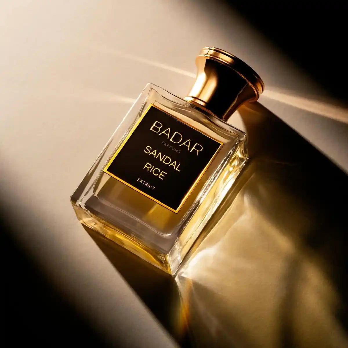 Flacon Sandal Rice de la Maison Badar Parfums sur une table avec la lueur du soleil