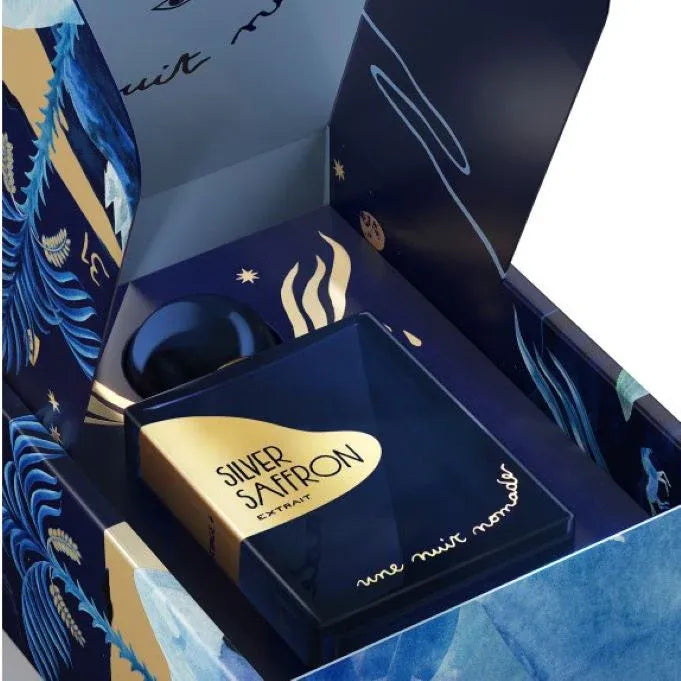 Flacon Silver Saffron Extrait de Une Nuit Nomade — parfum unisexe oriental-épicé très raffiné, s’ouvrant sur une explosion fruitée de framboise et litchi, coulée vers un cœur intense de safran et d’iris relevé d’une touche cuirée, et se posant sur un fond fumé de papyrus et myrrhe pour un sillage audacieux et profond.
