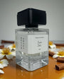Parfum Sombre Délice de MAISON ANAMA – flacon raffiné en verre transparent avec bouchon élégant, fragrance intense et envoûtante aux notes sombres et gourmandes
