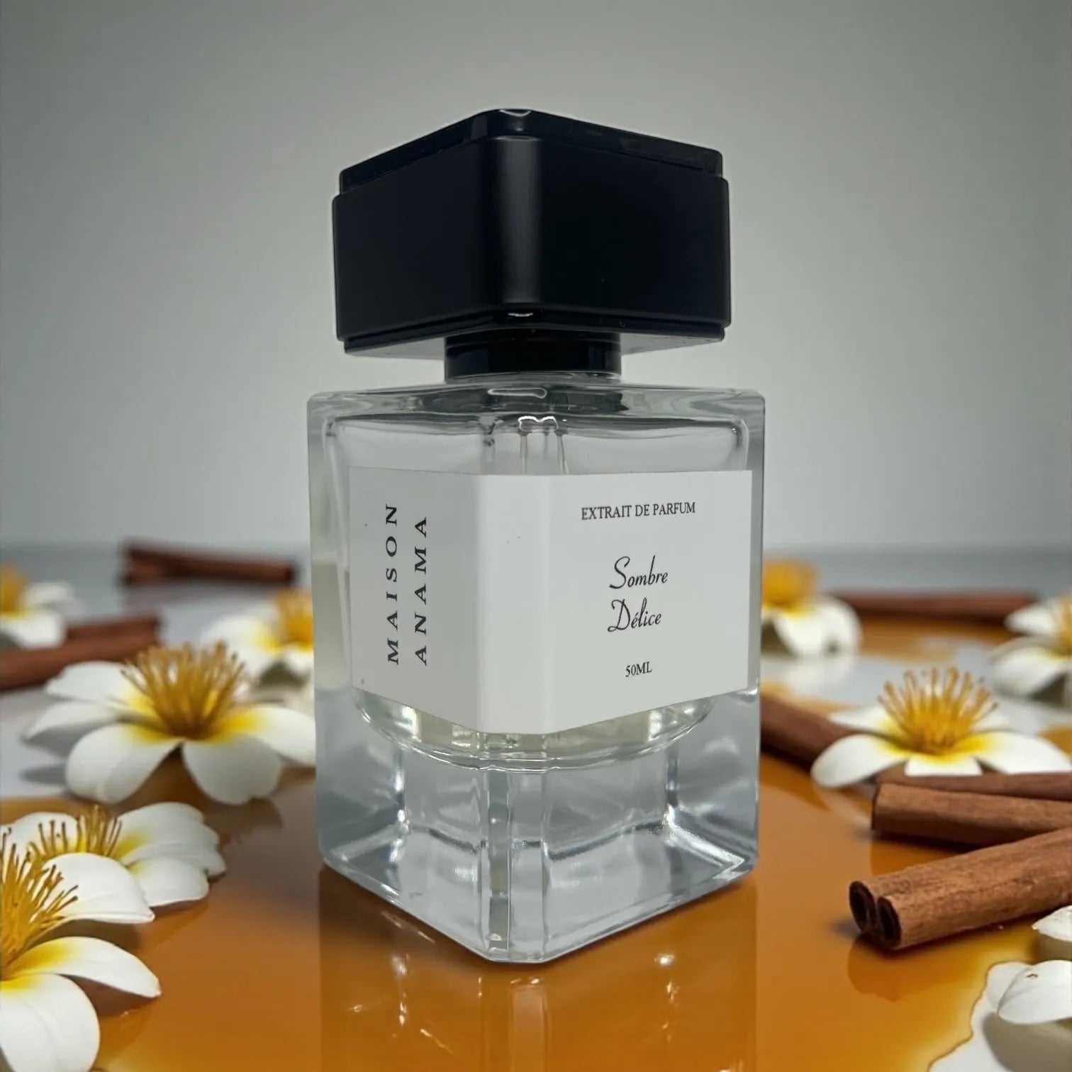 Parfum Sombre Délice de MAISON ANAMA – flacon raffiné en verre transparent avec bouchon élégant, fragrance intense et envoûtante aux notes sombres et gourmandes
