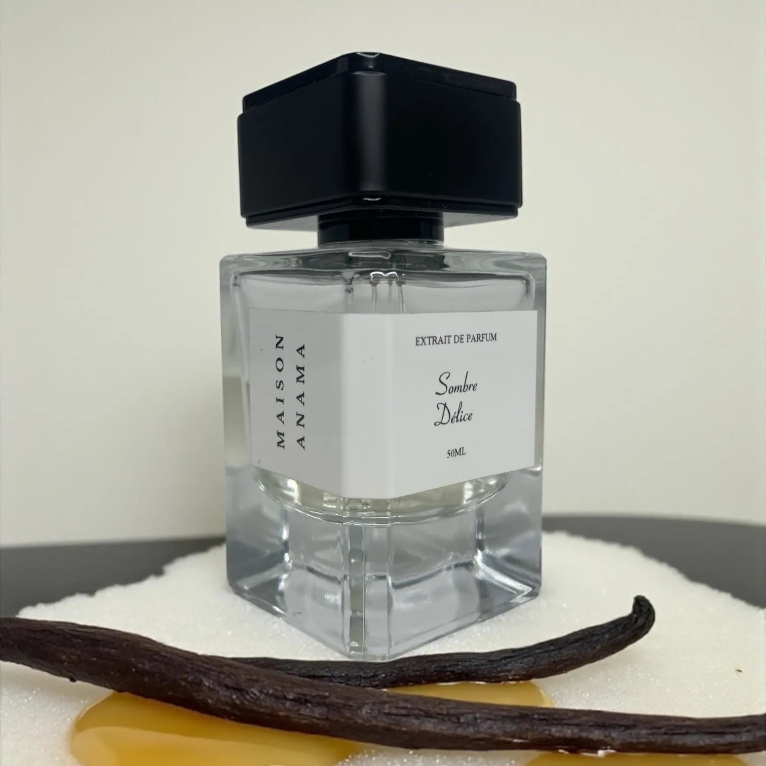 Parfum Sombre Délice de MAISON ANAMA – flacon raffiné en verre transparent avec bouchon élégant, fragrance intense et envoûtante aux notes sombres et gourmandes
