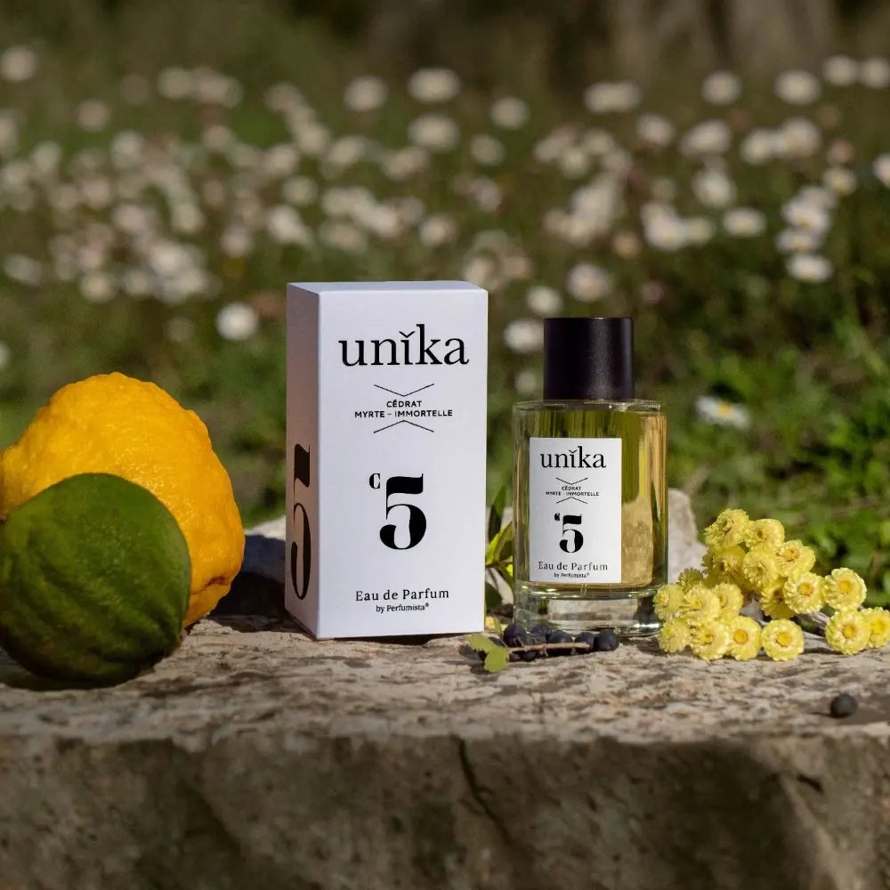 Unika N°5 Cédrat Myrte Immortelle – Boisé Corse Grasse eau de parfum sur un rocher avec des cédrat et un bouquet d'immortelle