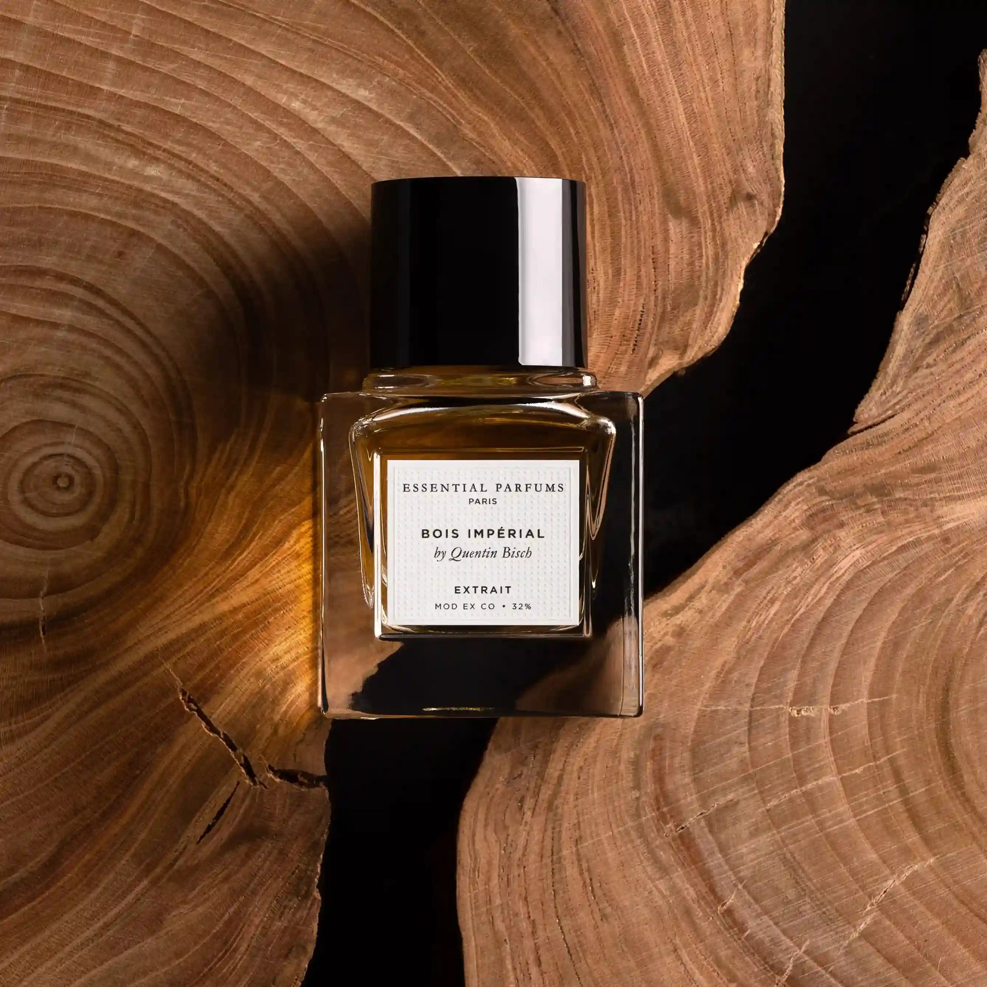 Parfums de niche Bois Impérial Extrait 30 ml – Essential Parfums, flacon parfum boisé épicé sur un fond élégant en bois découpé