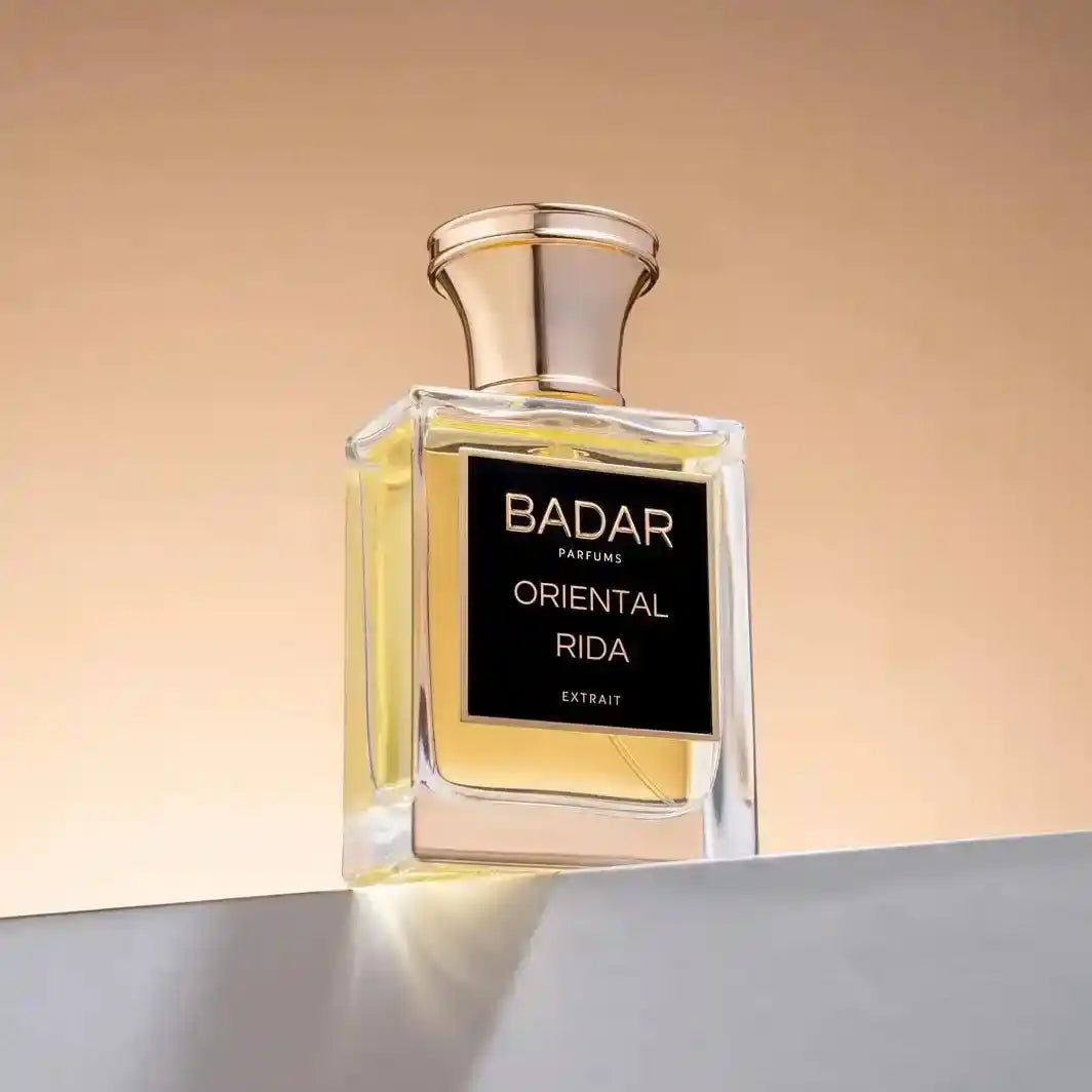 Flacon Oriental Rida de la Maison Badar Parfums, sur un mur blanc avec un fond orange type ensoleillé